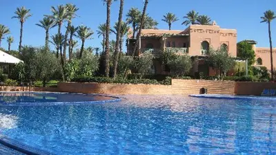 a large swimming pool in front of a house at Luxury apartement Palmeraie Village in Marrakech