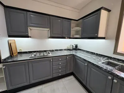a kitchen with black cabinets and a counter top at Duplex Menara Mall in Marrakech