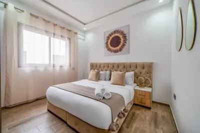 a bedroom with a large bed and a window at Emplacement idéal fraîcheur garantie, piscine netflix in Marrakech