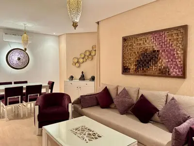 a living room with a couch and a table at Modern 3BR Apartment with Pool & Golf Views in Marrakech