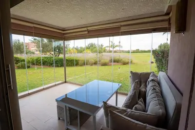 a living room with a couch and a glass table at Modern 3BR Apartment with Pool & Golf Views in Marrakech