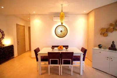 a dining room with a white table and chairs at Modern 3BR Apartment with Pool & Golf Views in Marrakech