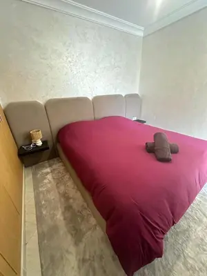 a large bed with a pink blanket in a room at Appartement 2 chambre cosy in Marrakech