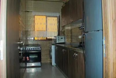 a kitchen with a blue refrigerator and a stove at apartment,5 min to airport, In a quiet place in Marrakech