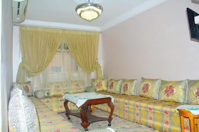 a living room with a couch and a table at apartment,5 min to airport, In a quiet place in Marrakech