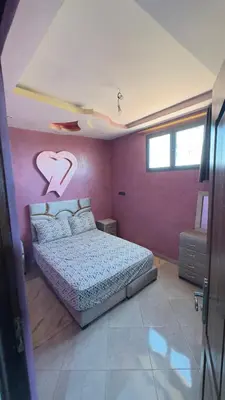 a bedroom with a bed with a heart painted on the wall at Aéroport hostel et chambre appartement studio Marrakech in Marrakech