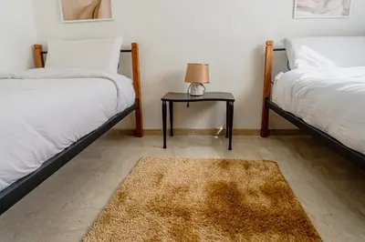 a bedroom with two beds and a table with a lamp at Appartement 2 bedroom Babylone center in Marrakech