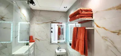 a bathroom with orange towels and a sink and mirror at Marrakech charme urbain à l'hivernage in Marrakech