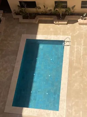 a large blue swimming pool in a building at Marrakech charme urbain à l'hivernage in Marrakech
