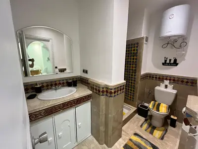 a bathroom with a sink and a toilet at Guéliz Bright apartment with pools in Marrakech