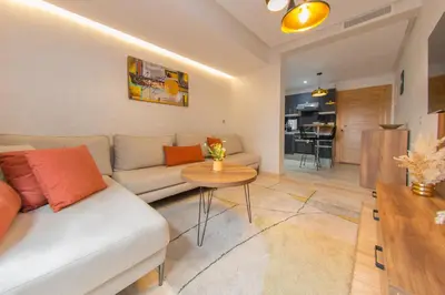 a living room with a white couch and a table at Appartement Plaza Madani in Marrakech