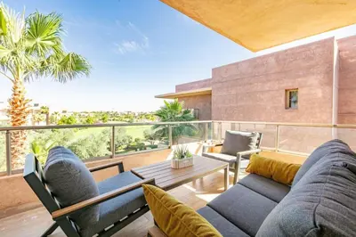 a living room with a couch and a table on a balcony at Spacious Apartment, Golf & Pool in Marrakech