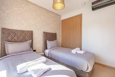 a bedroom with two beds with towels on them at Spacious Apartment, Golf & Pool in Marrakech