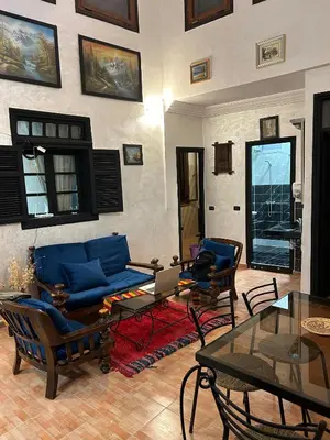 a living room with a blue couch and chairs at Dar Daroune in Marrakech