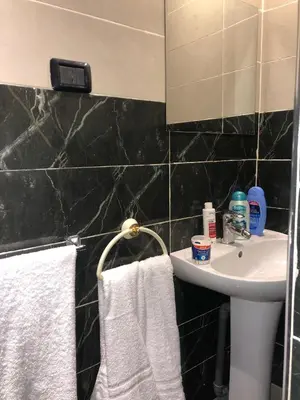 a bathroom with a sink and a mirror and towels at Dar Daroune in Marrakech