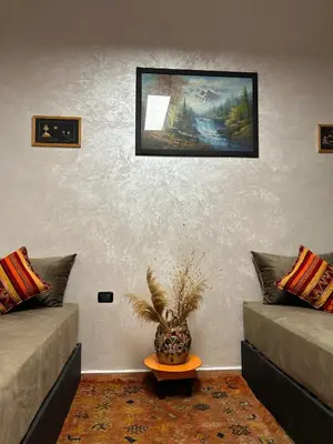 a living room with two couches and a painting on the wall at Dar Daroune in Marrakech