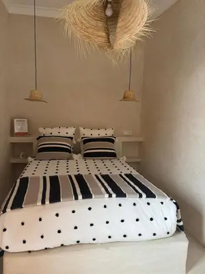 a bedroom with a black and white bed with two pillows at Dar Tiegezh in Marrakech
