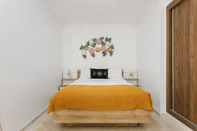 a bedroom with a bed with a yellow blanket at Pearl of Nour Prestige in Marrakech