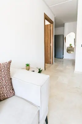 a living room with a white couch and a mirror at Pearl of Nour Prestige in Marrakech