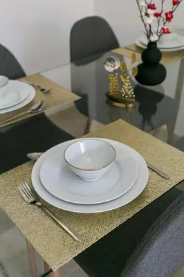 a table with a white bowl and a plate on it at Pearl of Nour Prestige in Marrakech