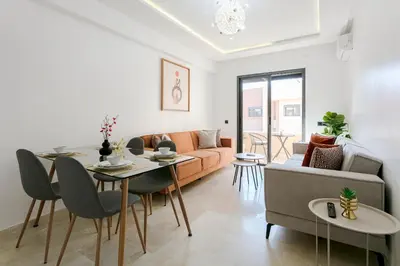 a living room with a couch and a table and chairs at Pearl of Nour Prestige in Marrakech