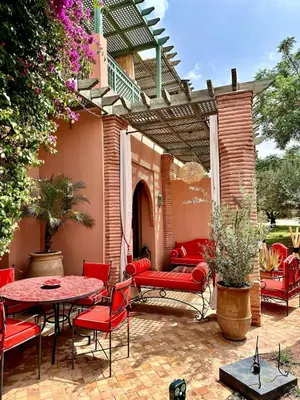 an outdoor patio with red chairs and a table at Le Palmito - 2BDR - Private Garden - Pool in Marrakech