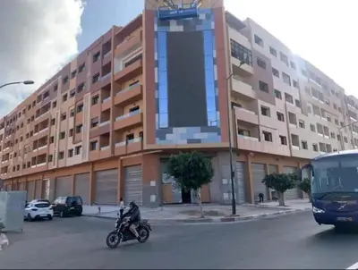 a man riding a motorcycle in front of a building at Appartement magnifique in Marrakech