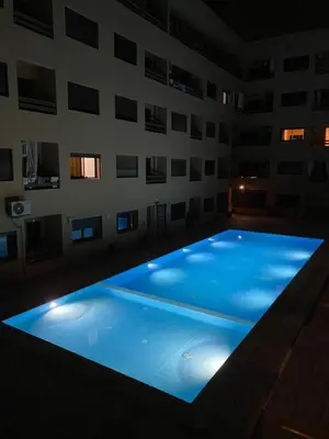 a large swimming pool in a building at night at Appartement magnifique in Marrakech