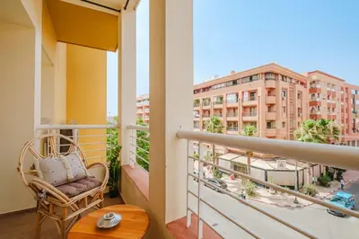 a balcony with a chair and a view of a building at Elegant and Confort Moderne au Coeur de la Ville in Marrakech