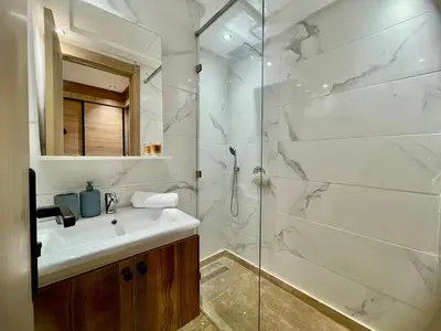 a white bathroom with a sink and a shower at Modern Oasis in Gueliz - Balcony & Comfort in Marrakech