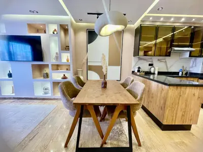 a kitchen with a wooden table and chairs at Modern Oasis in Gueliz - Balcony & Comfort in Marrakech