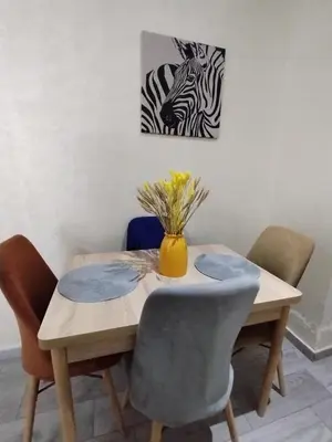 a table with chairs and a vase with a zebra at Appartement luxueux à louer in Marrakech