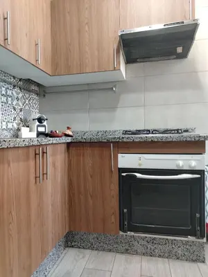a kitchen with a black oven and wooden cabinets at Appartement luxueux à louer in Marrakech