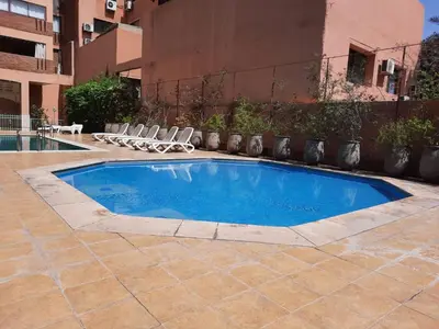 a small swimming pool with chairs and a building at Residence Sofia in Marrakech