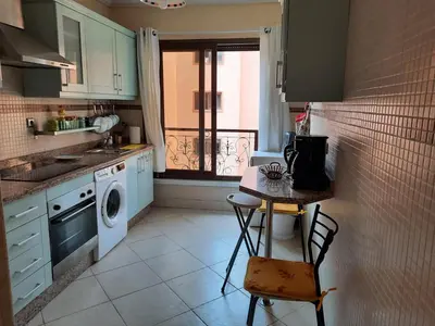 a kitchen with a table and a washing machine at Residence Sofia in Marrakech