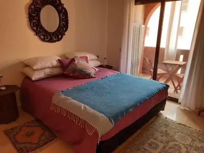 a bed with pillows and a mirror in a bedroom at Residence Sofia in Marrakech