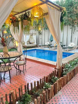 a swimming pool with a table and chairs and a tent at Villa Elysia Marrakech, Piscine sans vis à vis in Marrakech