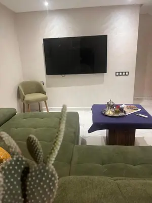 a living room with a couch and a table and a tv at Marrakech duplex apartment in Marrakech