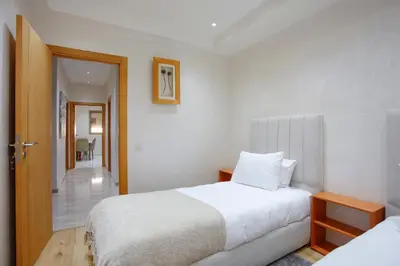 a hotel room with two beds and a hallway at The Smooth Stay Marrakech Pool in Marrakech