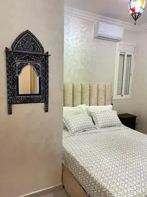 a bedroom with a bed and a mirror on the wall at Airport Apartment in Marrakech