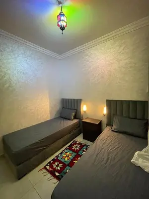 a bedroom with two beds and a chandelier at Airport Apartment in Marrakech
