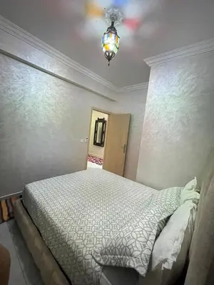 a bedroom with a bed and a ceiling fan at Airport Apartment in Marrakech