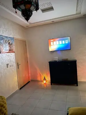 a room with a television on a wall at Airport Apartment in Marrakech