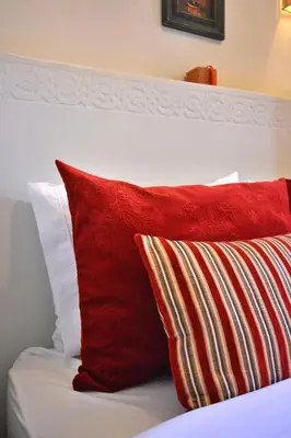 a bed with red and white pillows on it at Beldi House in Marrakech