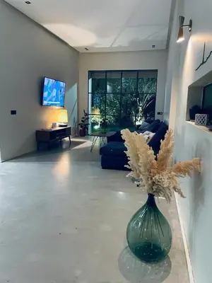 a living room with a green vase with flowers in it at Magnifique villa privée piscine 3ch, centre in Marrakech