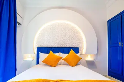 a bedroom with a blue and white bed with yellow pillows at Suite Majorelle l Gueliz,balcon,clim, Netflix,WiFi in Marrakech