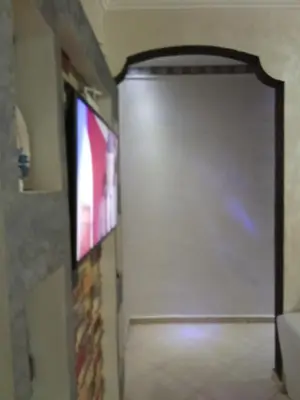 a room with a door with a tv and a wall at Basatine gelez in Marrakech