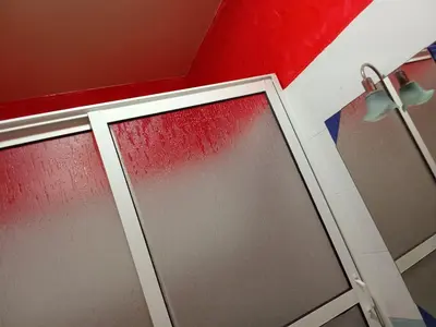 a bathroom with a glass door and a red wall at Basatine gelez in Marrakech