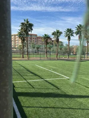 a tennis court with palm trees and a building at Comfort & Elegance Marrakech in Marrakech