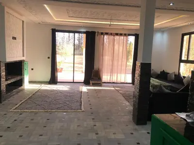 a living room with a large glass door and a couch at Dar AZZARO in El Rhechat